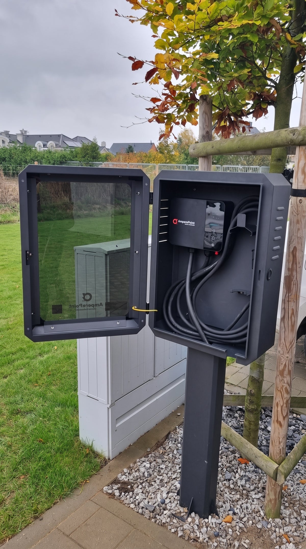 Open AMP BOX EV charger cabinet on a mounting pole with an AmperePoint wallbox (EVSE) and coiled Type 2 cable inside